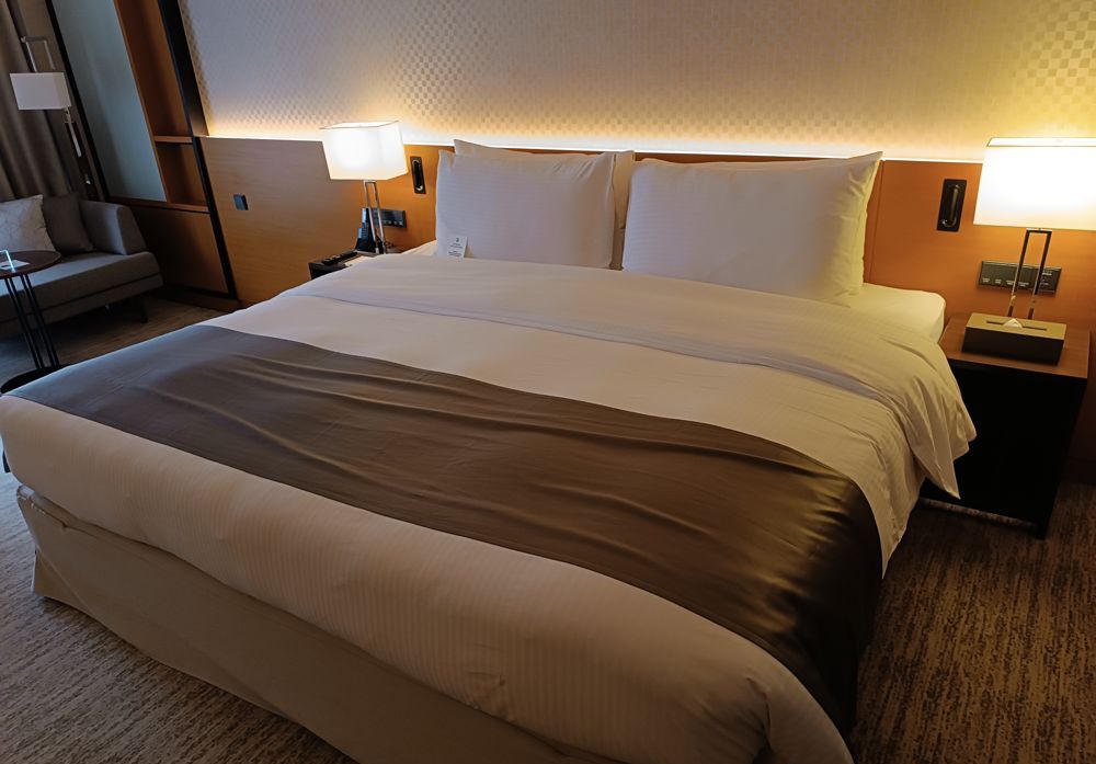 Freshly made bed with crisp white linens